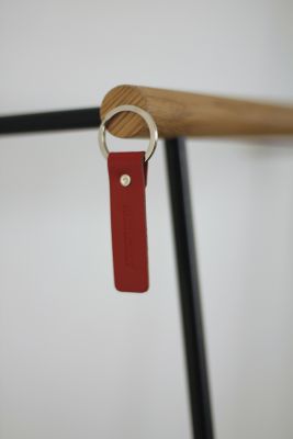 Detailaufnahme: Little Leanon II Stummer Diener, schwarze Säule mit rotem Schlüsselanhänger. Roomsafari Möbel.